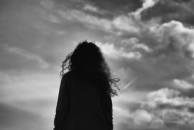 Silhouette of woman against cloudy sky