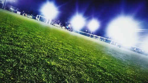 Low angle view of soccer field against sky at night