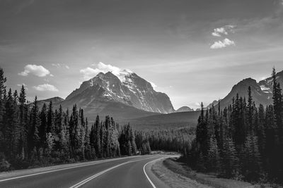 Road by mountains against sky