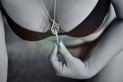 Midsection of sensuous woman wearing pendant key