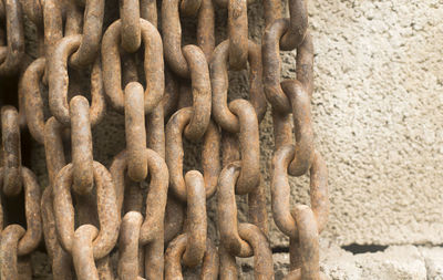 Close-up of rusty chain against wall