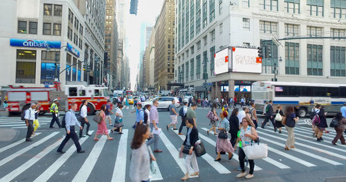 Group of people walking on road in city