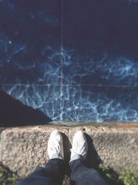 Low section of person standing in water