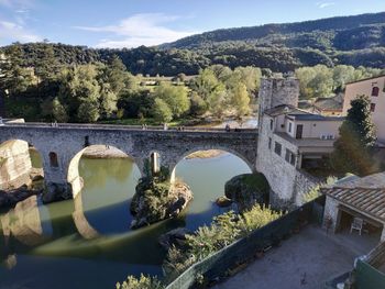 Arch bridge over river against buildings