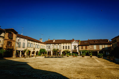 Buildings in city against clear blue sky