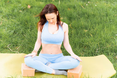 Full length of woman sitting on grass