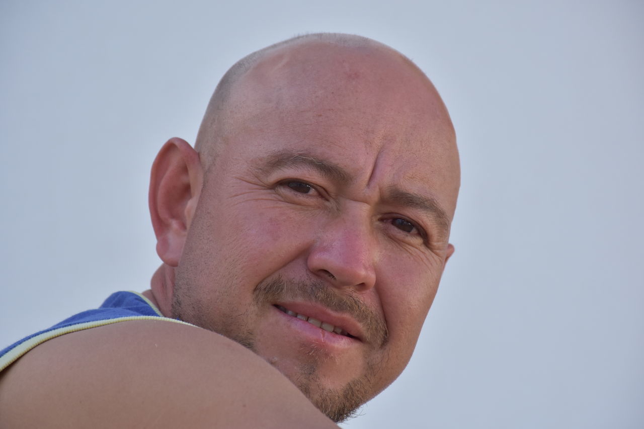 PORTRAIT OF MATURE MAN AGAINST SKY