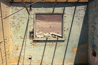 High angle view of broken window on abandoned wall