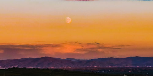 Scenic view of silhouette mountains against sky during sunset