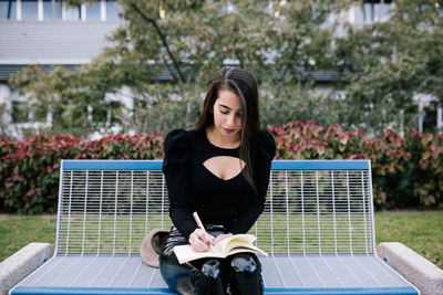 Full length of woman sitting outdoors