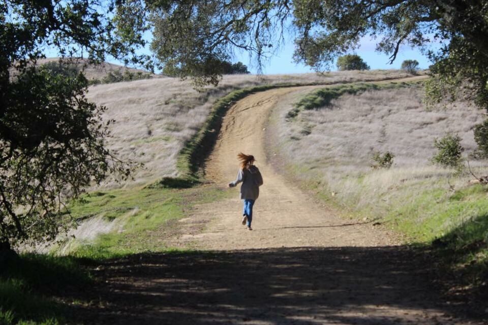 FULL LENGTH REAR VIEW OF MAN WALKING ON ROAD