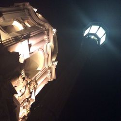 Low angle view of illuminated street lights at night