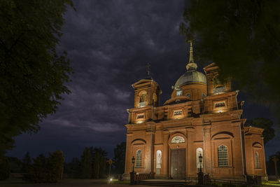 Low angle view of illuminated building against sky at night