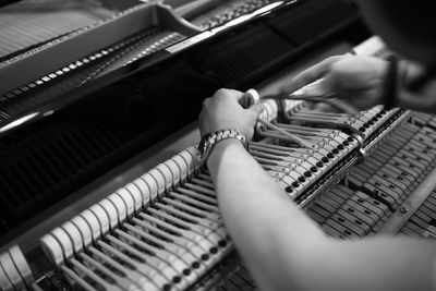 Close-up of person fixing piano