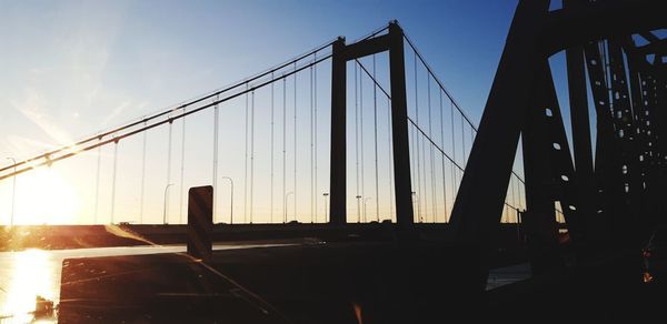 Suspension bridge against sky during sunset