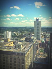 View of cityscape against cloudy sky