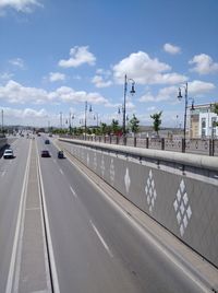 Cars on road against sky in city