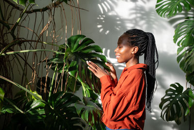 Side view of woman looking away against plants