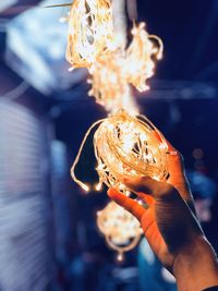 Close-up of hand holding illuminated lighting equipment