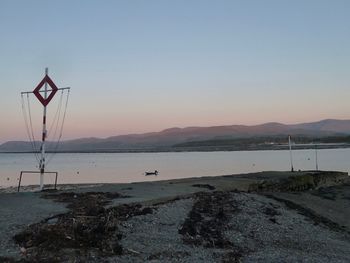 Scenic view of beach against clear sky during sunset
