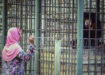 Woman looking at animal in zoo