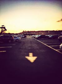 Cars on road against sky during sunset