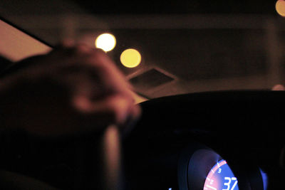 Blurred motion of man seen through car windshield at night