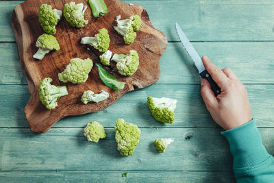 High angle view of hand holding bread on cutting board