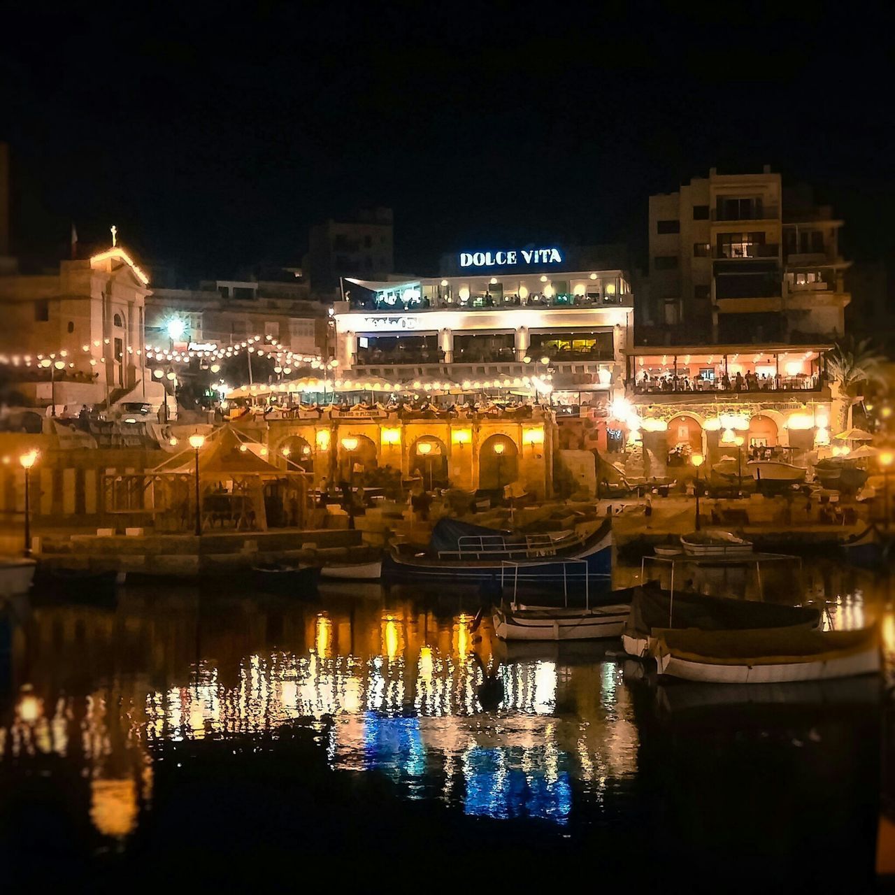 illuminated, architecture, building exterior, water, night, built structure, reflection, waterfront, nautical vessel, moored, boat, city, transportation, river, mode of transport, outdoors, sky, building, clear sky, travel destinations