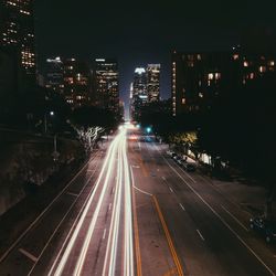 High angle view of illuminated street amidst buildings at night