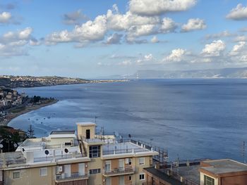 High angle view of sea by buildings against sky