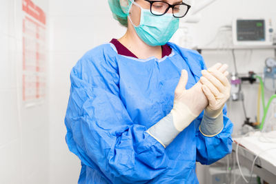 Female doctor wearing gloves at hospital