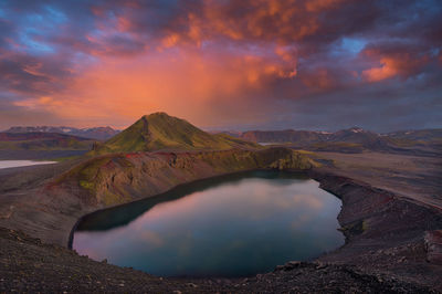 Scenic view of lake and mountains against sky during sunset