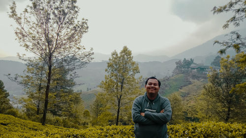 Portrait of young man against plants and trees against sky