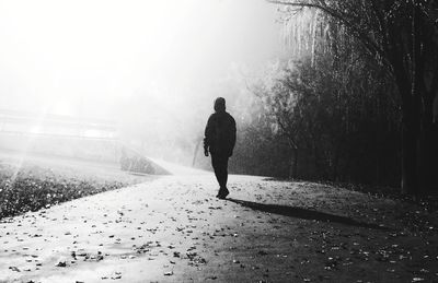 Rear view of man walking on road