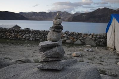 Stack of rocks on beach against sky