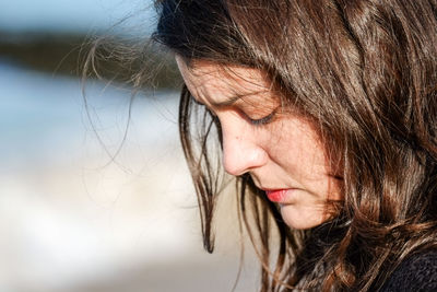 Close-up of beautiful woman looking down during sunny day