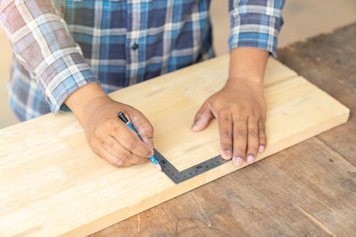 Midsection of man working on wood