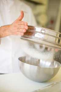 Close-up of man preparing food in bowl