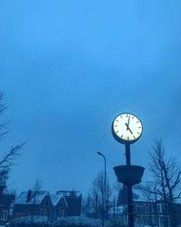 Low angle view of clock tower against blue sky