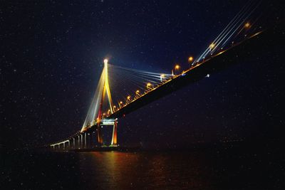 Low angle view of illuminated bridge against sky at night