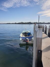 Sailboats moored on sea against sky