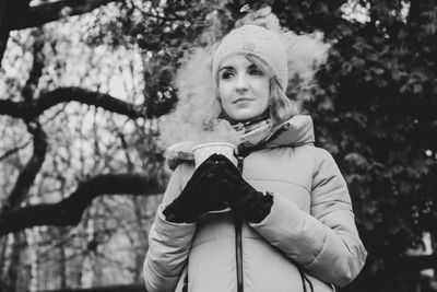 Portrait of woman against trees during winter