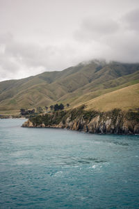 Scenic view of sea and mountains against sky