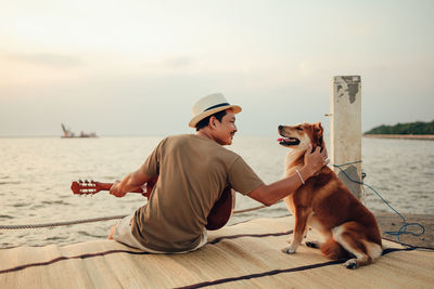 Woman with dog sitting in the sea