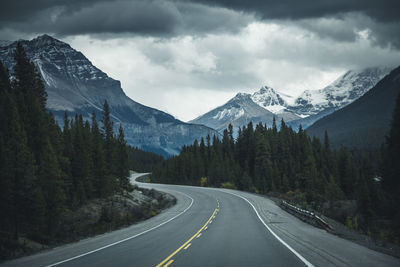 Road by mountains against sky