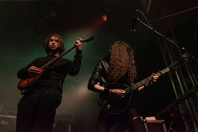 People playing guitar at music concert