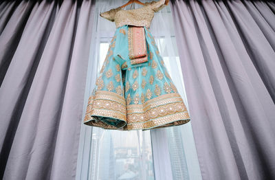 Close-up of clothes hanging on window at home