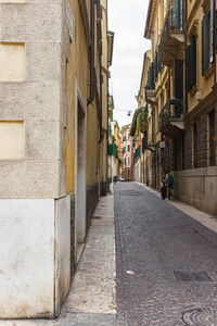 Rear view of narrow alley amidst buildings in city