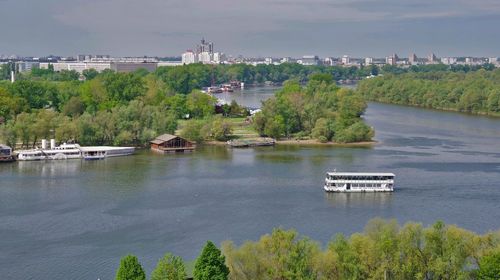 Scenic view of river by trees against sky